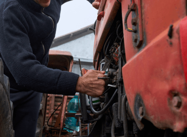 Operario revisando un tractor para realizar mantenimiento correctivo vs preventivo